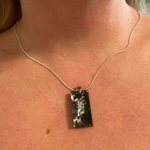 Black and silver necklace with pendant.